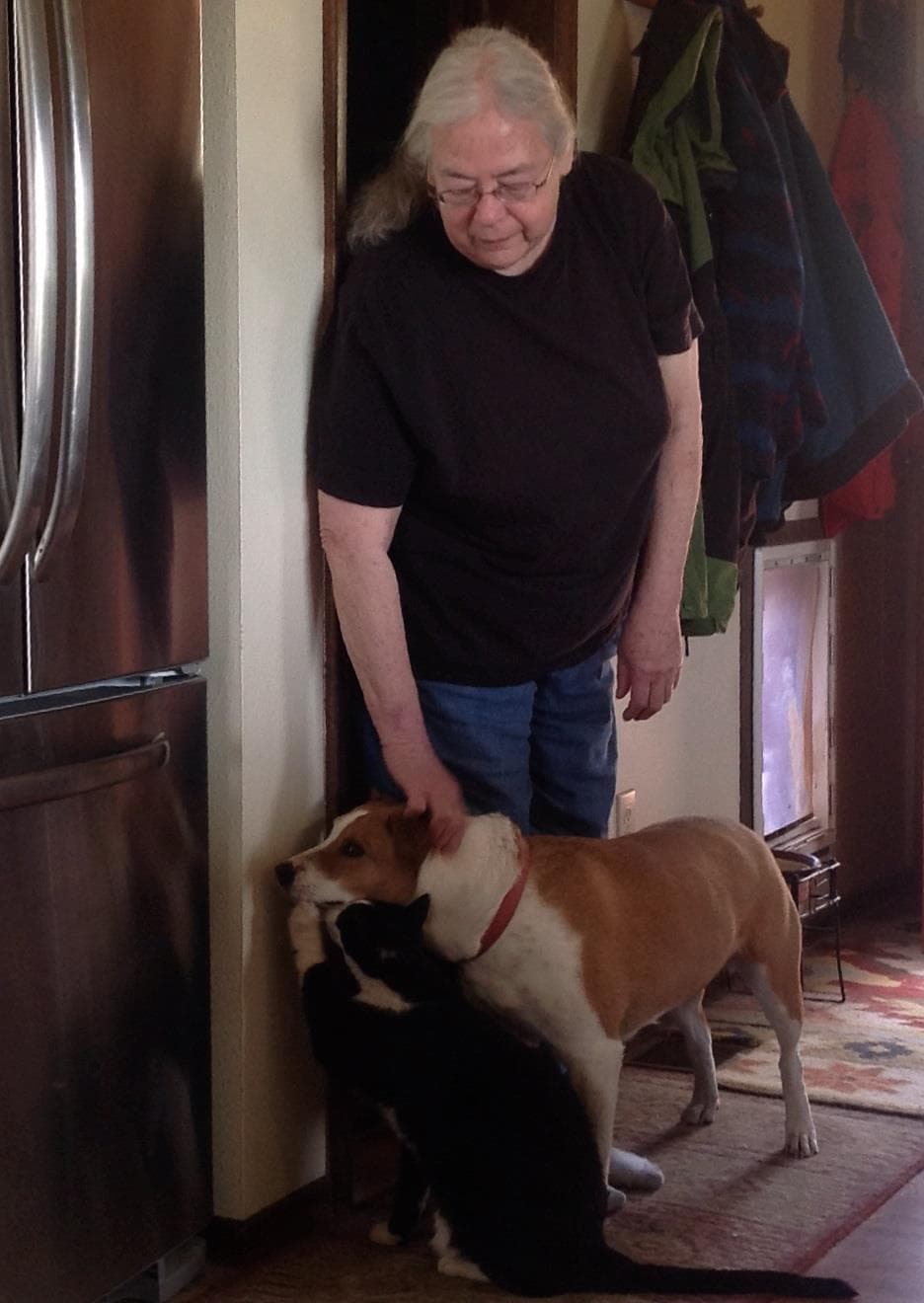 Susan Robbins standing with a dog and cat