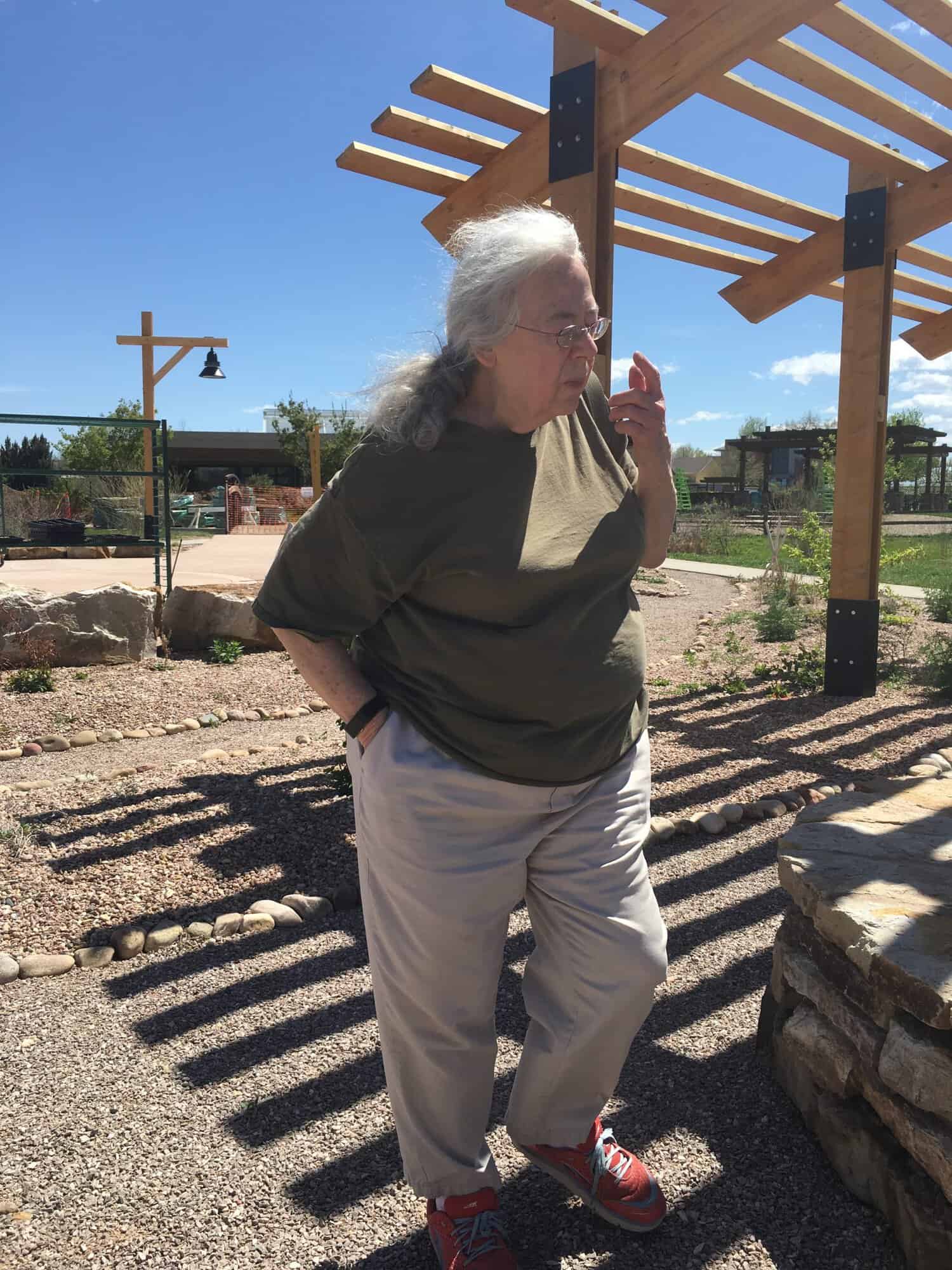 Susan walking under a pergola at The Gardens on Spring Creek